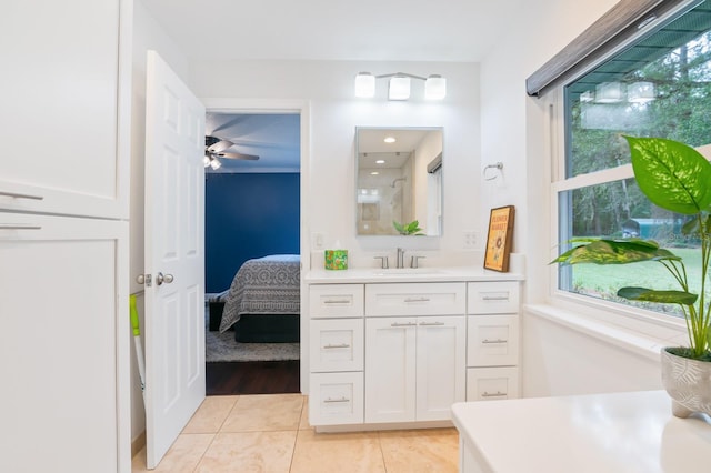 bathroom with a shower with door, vanity, ceiling fan, and tile patterned floors