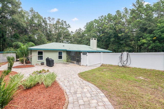 back of property with a lawn and a patio area