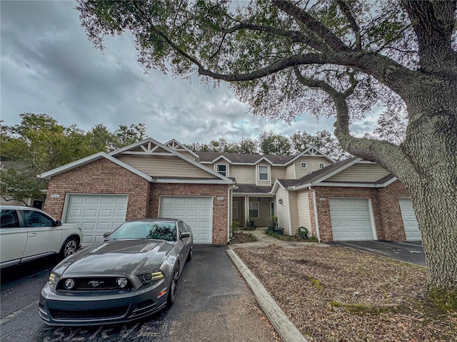 view of front of property featuring brick siding, an attached garage, and driveway