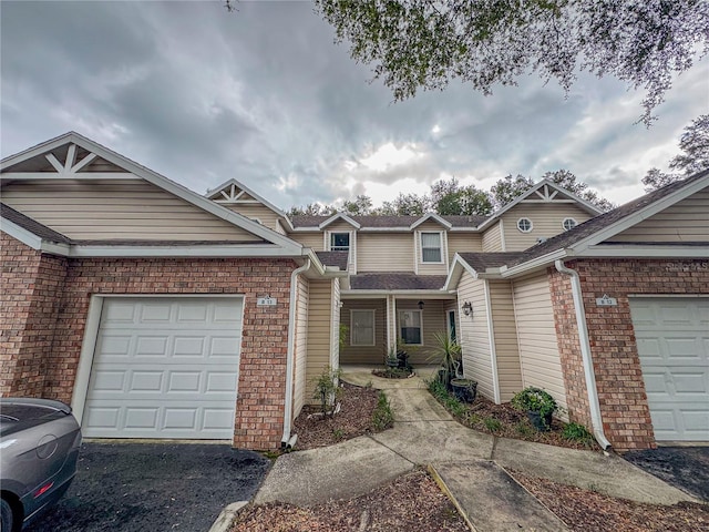 view of front of home with aphalt driveway, brick siding, and a garage