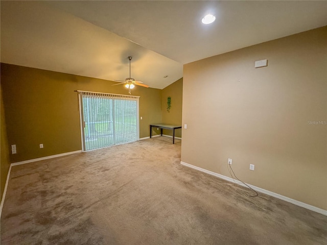 empty room featuring lofted ceiling, carpet, baseboards, and ceiling fan