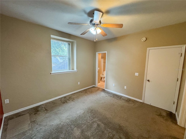 unfurnished bedroom featuring ceiling fan, carpet, baseboards, and ensuite bathroom