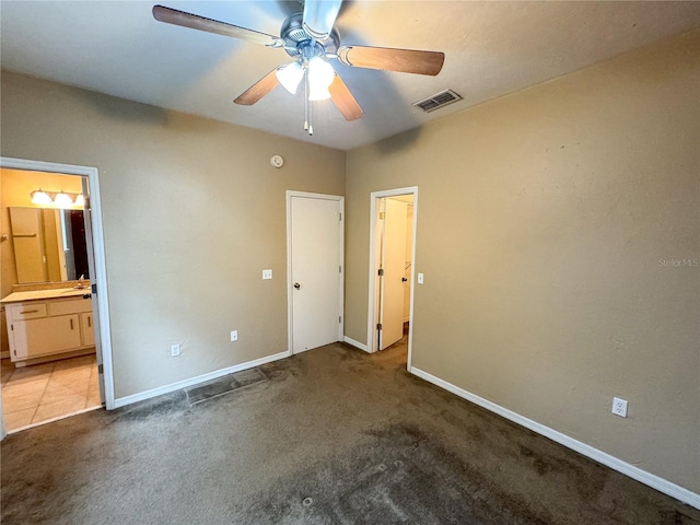 unfurnished bedroom featuring light colored carpet, ceiling fan, and ensuite bathroom