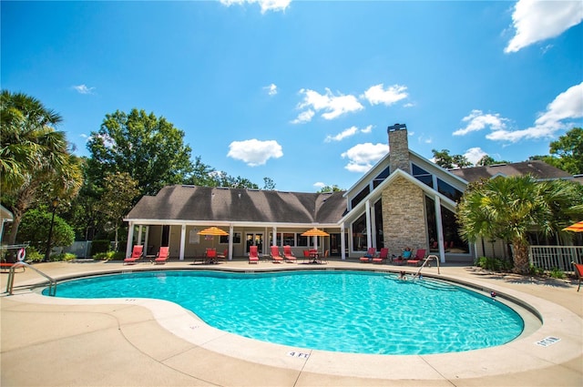 community pool featuring fence and a patio area