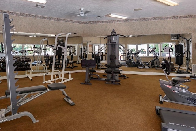 exercise room featuring a textured ceiling, visible vents, and a ceiling fan