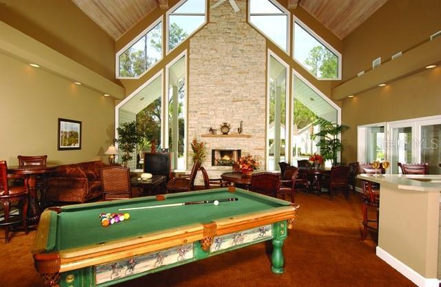 game room featuring high vaulted ceiling, wooden ceiling, billiards, and a stone fireplace