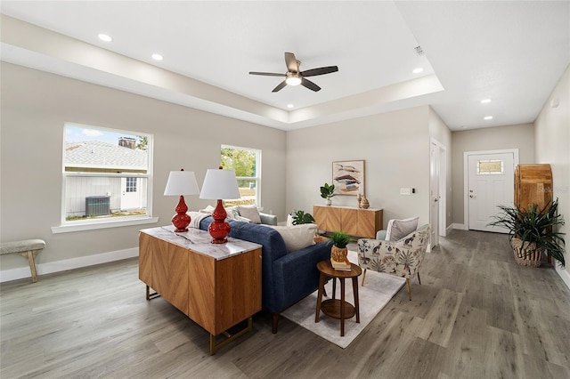 bedroom with ceiling fan, a raised ceiling, and wood-type flooring