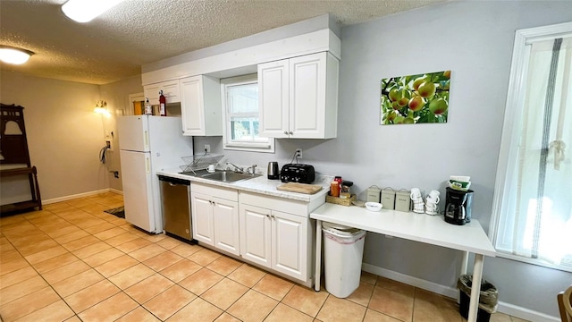 kitchen featuring dishwasher, white cabinetry, light tile patterned floors, and sink