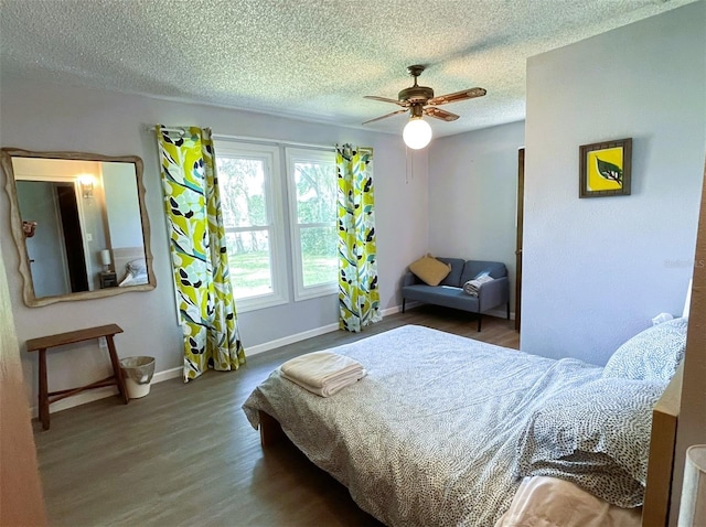 bedroom with a textured ceiling, hardwood / wood-style floors, and ceiling fan