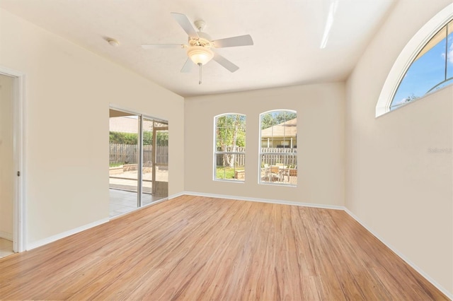 spare room featuring a ceiling fan, light wood-type flooring, and baseboards