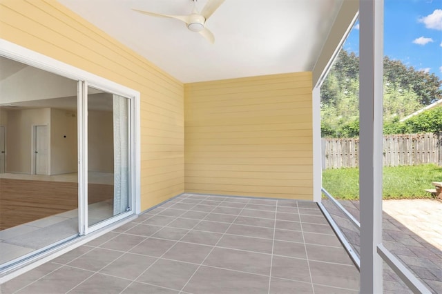 unfurnished sunroom with a ceiling fan and a wealth of natural light