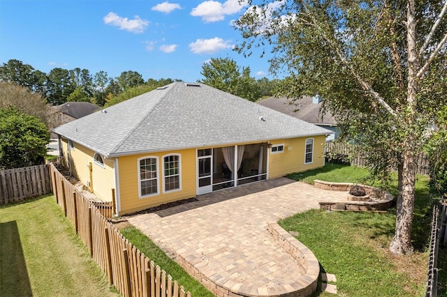 back of property featuring a yard, an outdoor fire pit, a fenced backyard, and a patio