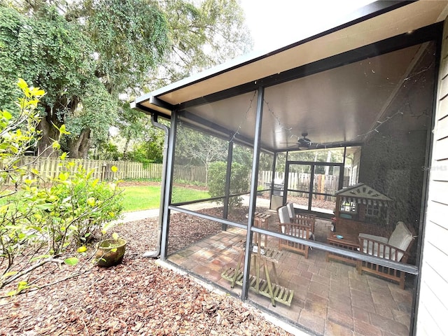 view of patio with ceiling fan and a sunroom