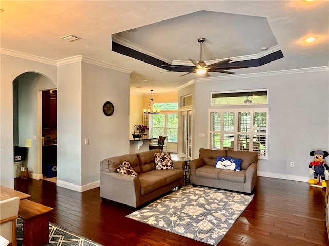 living room with ceiling fan with notable chandelier, crown molding, and dark hardwood / wood-style flooring