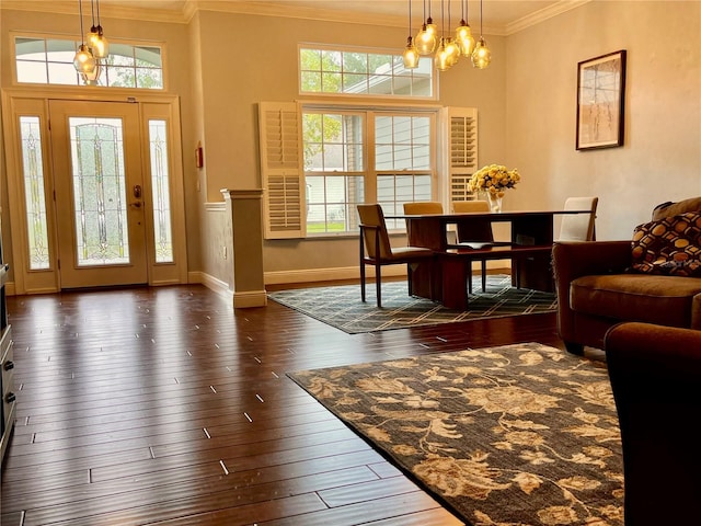 entryway with a notable chandelier, crown molding, and dark hardwood / wood-style flooring