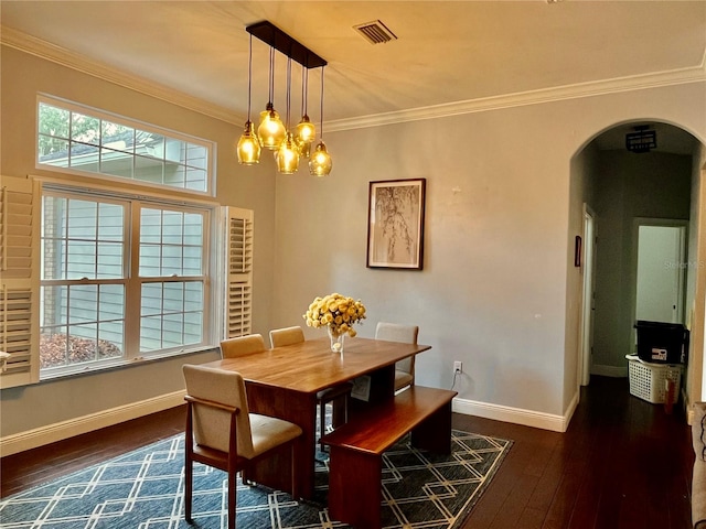 dining room with dark wood-type flooring, ornamental molding, and a notable chandelier