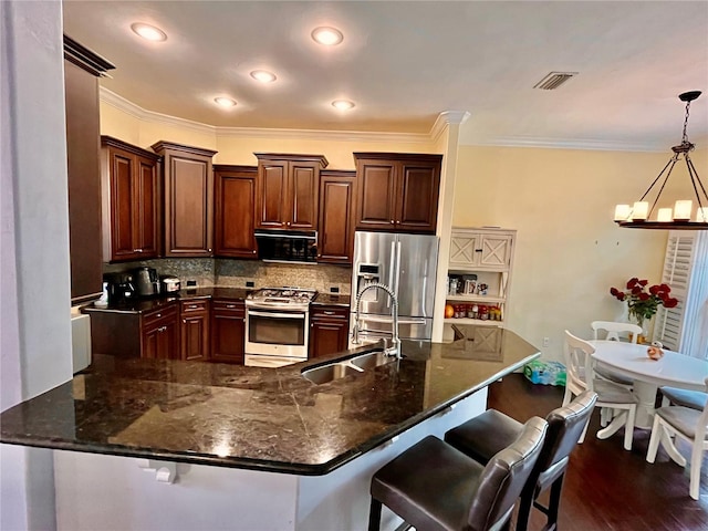 kitchen featuring stainless steel appliances, tasteful backsplash, dark wood-type flooring, sink, and pendant lighting