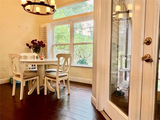 dining space featuring a notable chandelier and dark wood-type flooring