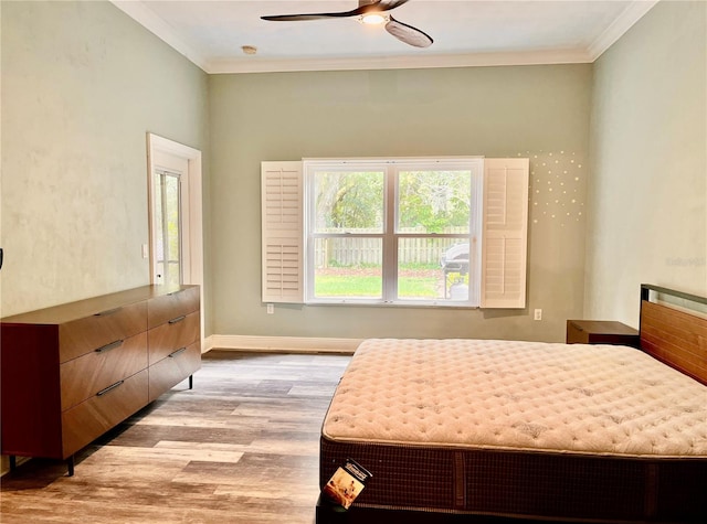 bedroom with ornamental molding, ceiling fan, and light hardwood / wood-style flooring