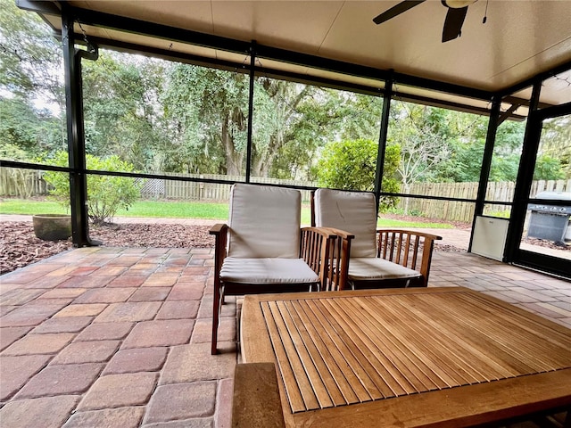 unfurnished sunroom featuring ceiling fan