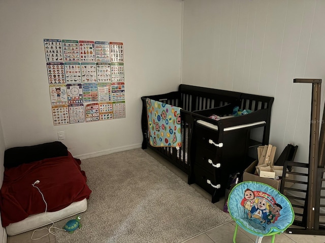 carpeted bedroom featuring a nursery area