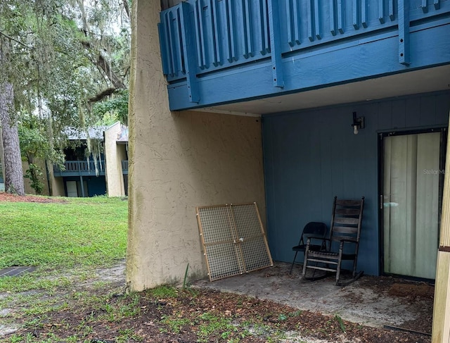 view of side of home featuring a lawn and a balcony