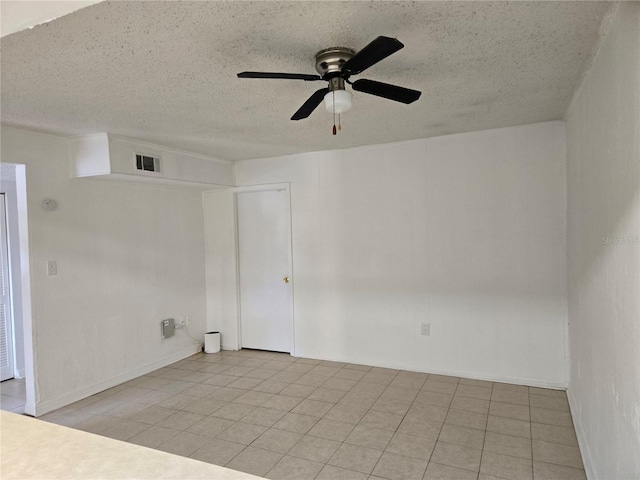2811 SW Archer Rd Unit R-143, Gainesville, FL 32608 - unfurnished room featuring a ceiling fan, a textured ceiling, light tile patterned floors, and baseboards