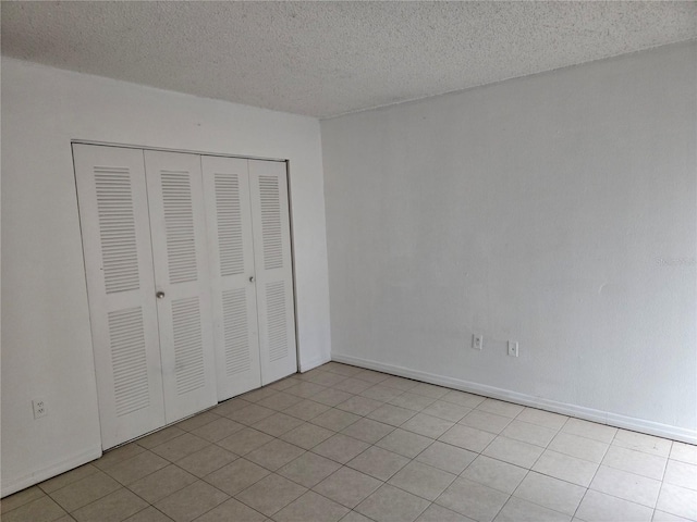 2811 SW Archer Rd Unit R-143, Gainesville, FL 32608 - unfurnished bedroom featuring a textured ceiling, a closet, and baseboards