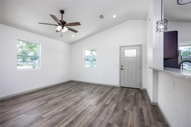 interior space with a sink, visible vents, lofted ceiling, a ceiling fan, and wood finished floors