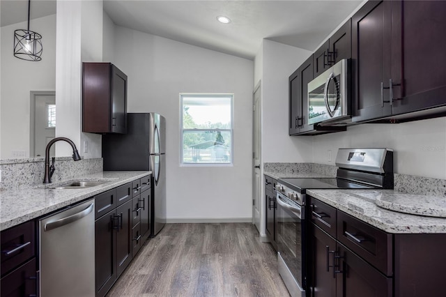 kitchen featuring stainless steel appliances, light wood-style flooring, a sink, and plenty of natural light