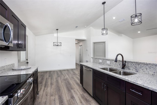 kitchen featuring sink, light hardwood / wood-style floors, stainless steel appliances, lofted ceiling, and decorative light fixtures