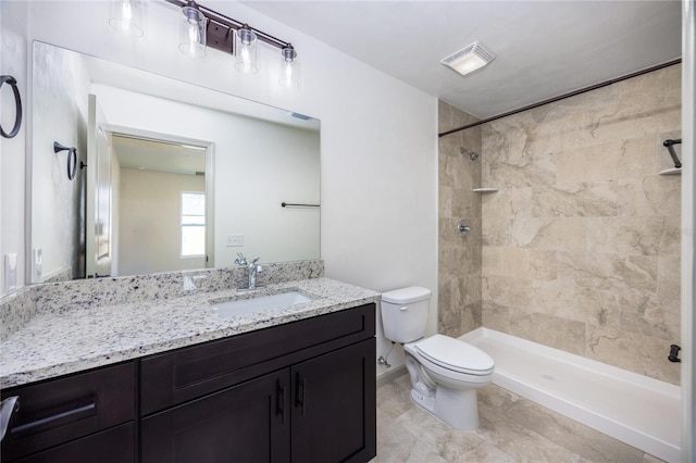 full bath featuring visible vents, a tile shower, vanity, and toilet