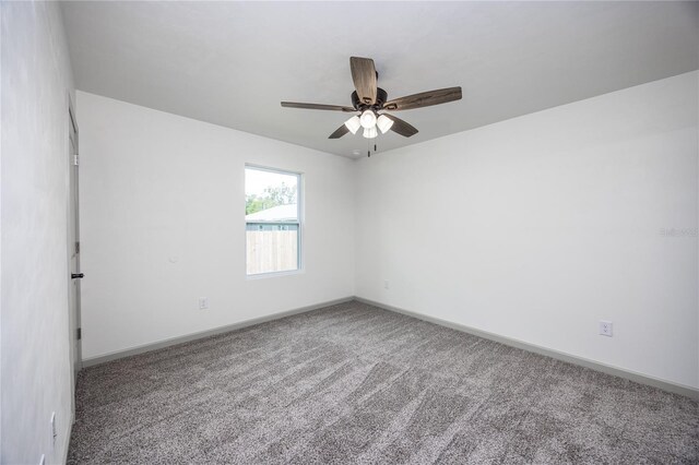 spare room featuring ceiling fan, baseboards, and carpet flooring