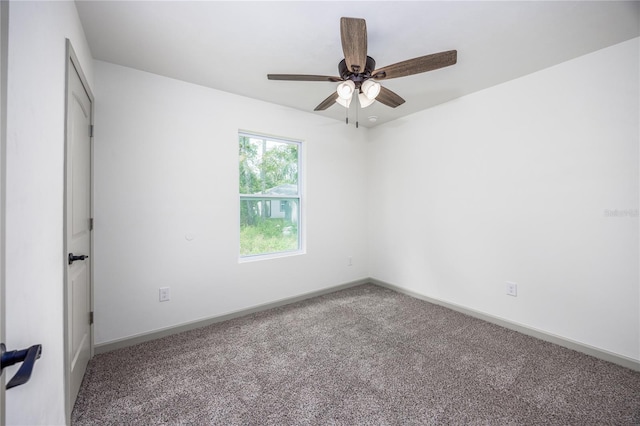 empty room featuring ceiling fan and carpet