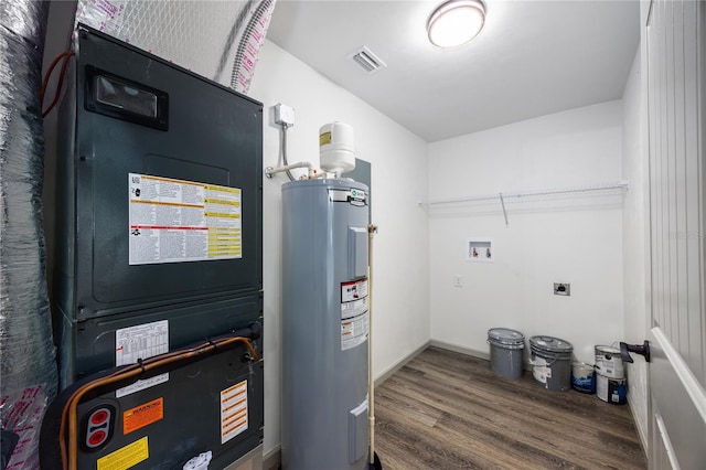 utility room featuring heating unit, electric water heater, and visible vents