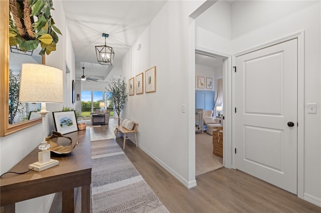 hall featuring an inviting chandelier and light hardwood / wood-style flooring