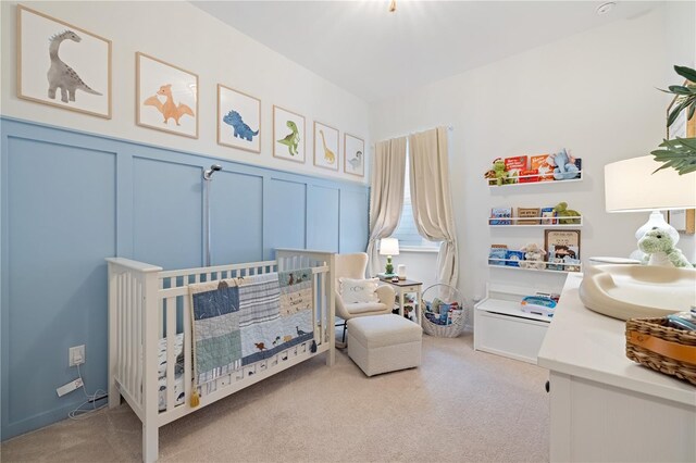 carpeted bedroom featuring a crib