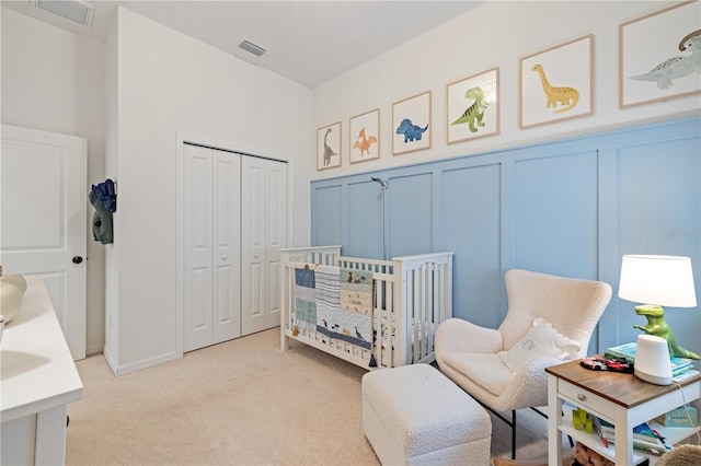 carpeted bedroom with a nursery area and a closet