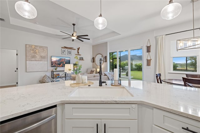 kitchen featuring dishwasher, a tray ceiling, sink, and white cabinets