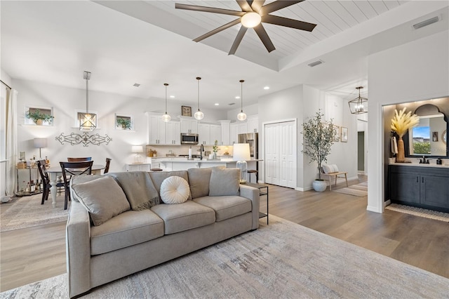 living room with wood-type flooring, sink, wooden ceiling, and ceiling fan