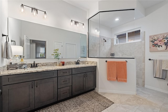 bathroom featuring a tile shower and vanity