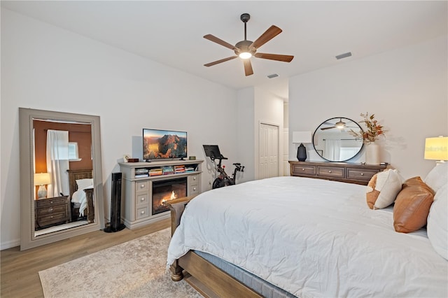 bedroom with ceiling fan, light wood-type flooring, and a closet