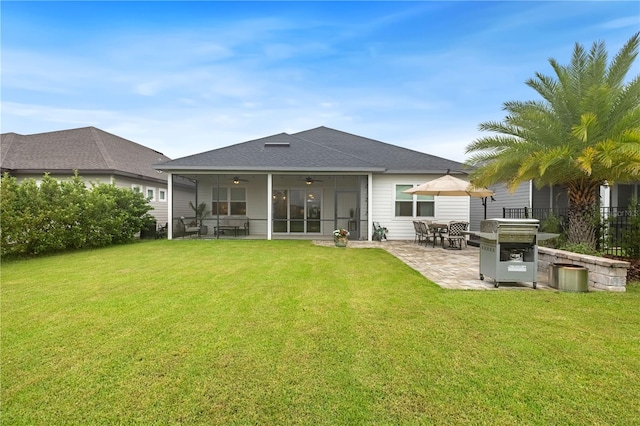 back of property with a patio, ceiling fan, and a yard