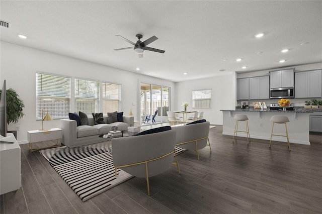 living room with dark hardwood / wood-style floors and ceiling fan