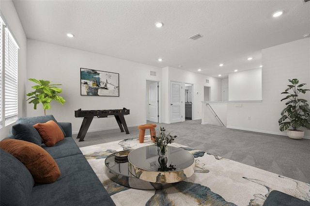 living room featuring light carpet, a textured ceiling, and plenty of natural light