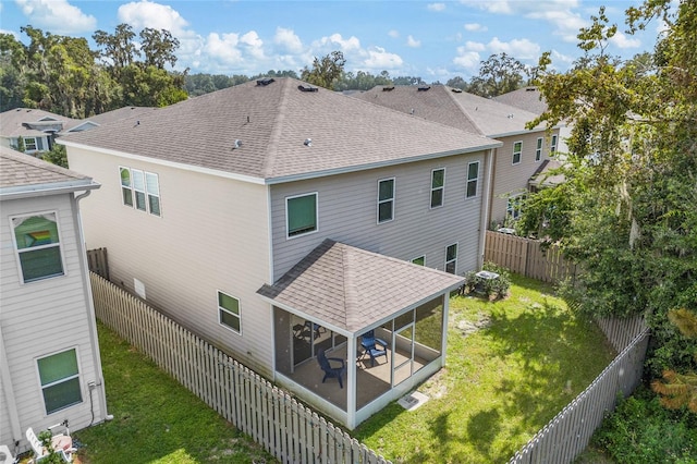 rear view of property featuring a sunroom and a lawn