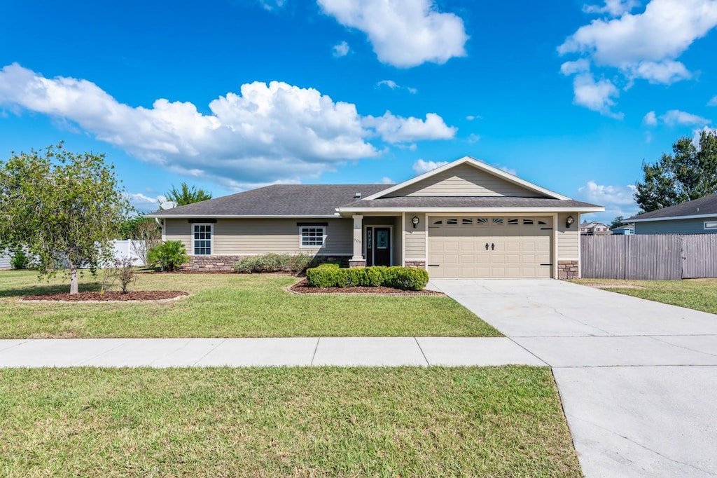 ranch-style home featuring a garage and a front yard