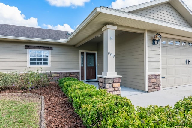 entrance to property featuring covered porch and a garage