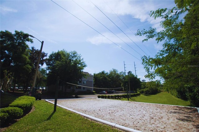 view of property's community featuring a yard and volleyball court