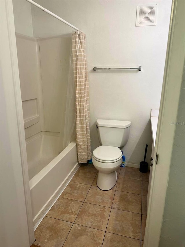 bathroom featuring shower / bath combination with curtain, tile patterned floors, and toilet